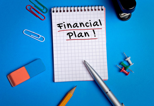 Financial Plan word on notebook on background
